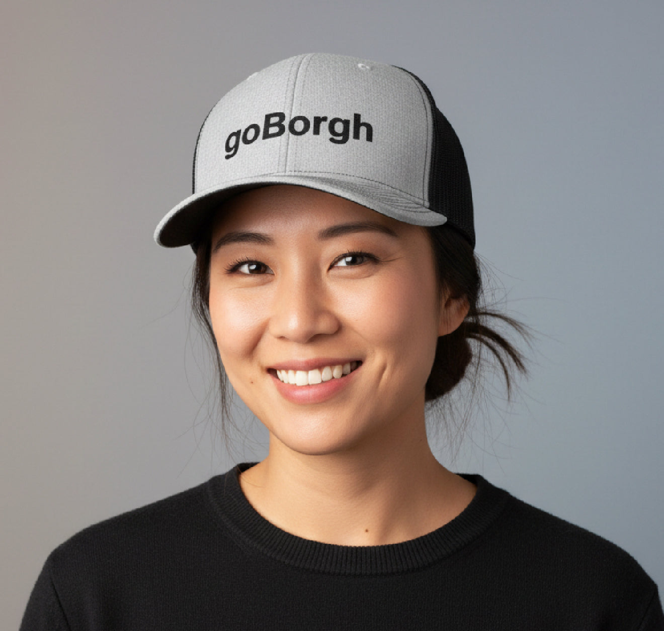 woman wearing goBorgh snapback trucker hat smiling outdoors