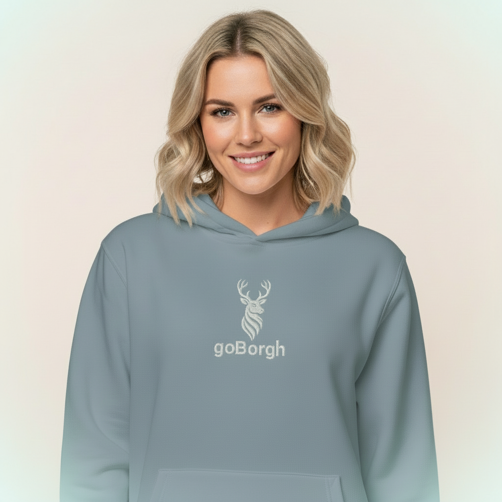 Female model wearing dusty blue goBorgh® Highland Frontier™ stag hoodie, portrait lifestyle view
