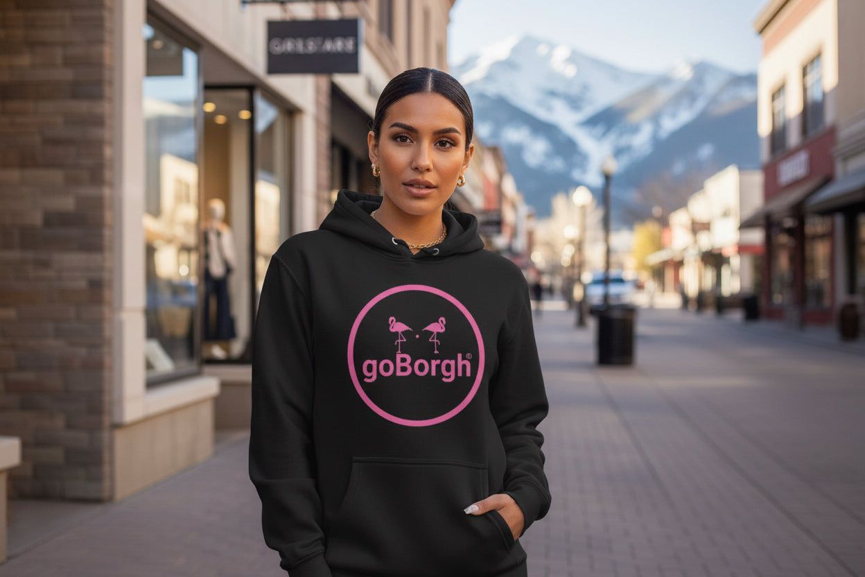 Model wearing the goBorgh® Flock of Flamingos Circle Badge Hoodie in black with pink circle badge logo, styled for casual lifestyle wear.