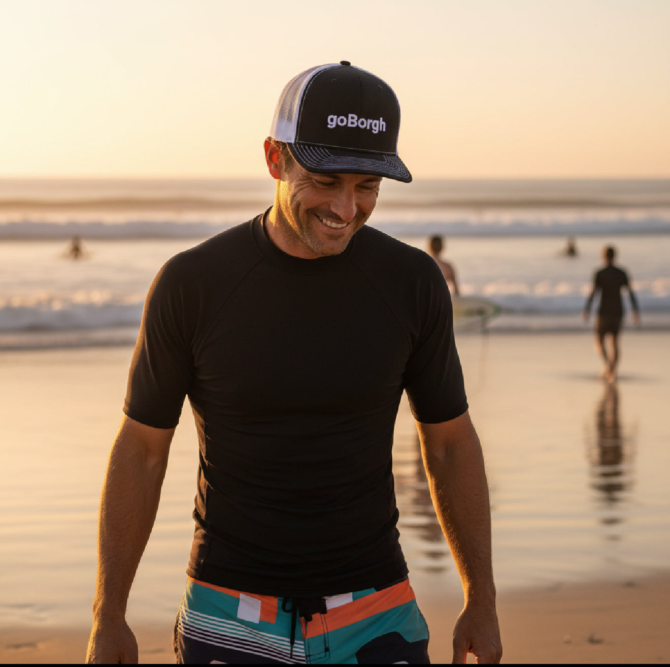 man wearing goBorgh snapback trucker hat walking on beach