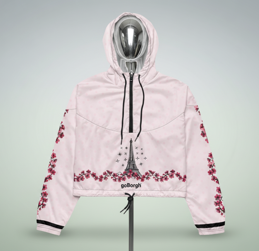 Studio image of pale pink goBorgh brand Paris in Bloom Eiffel Tower cherry blossom half zip windbreaker showing front design, half zip closure, and cropped fit