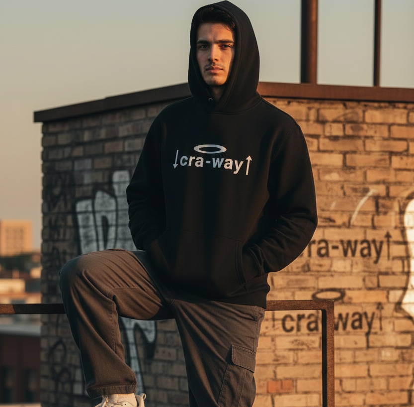 Model wearing a black cra-way™ Street Code oversized hoodie standing against a brick wall in an urban setting