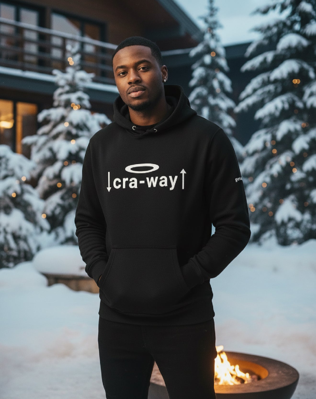 Person wearing a black hoodie with a logo and text in a snowy outdoor setting