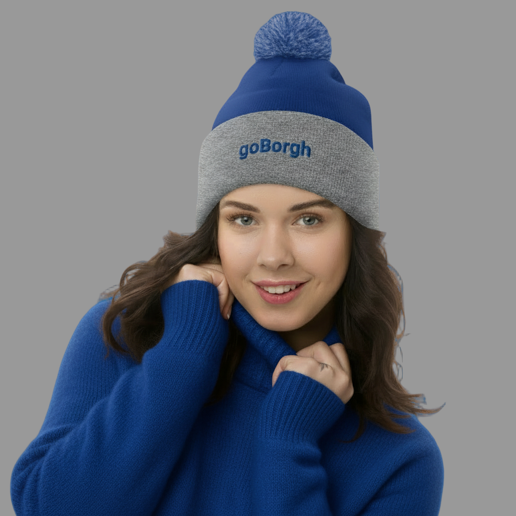 Woman wearing a blue and gray goBorgh knit beanie with pom in a cold-weather lifestyle shot
